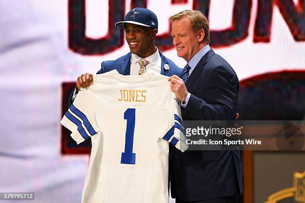 Byron Jones is selected by the Dallas Cowboys for the 27th pick of the first round and poses with NFL Commissioner Roger Goodell during round 1 of...