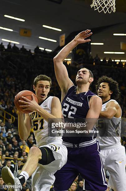 Iowa Hawkeyes forward Nicholas Baer tries to drive around Northwestern center Alex Olah during a Big Ten Conference mens basketball game between the...