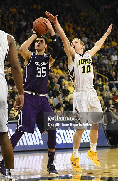 Iowa Hawkeyes guard Mike Gesell tries to block a shot by Northwestern forward Aaron Falzon during a Big Ten Conference mens basketball game between...