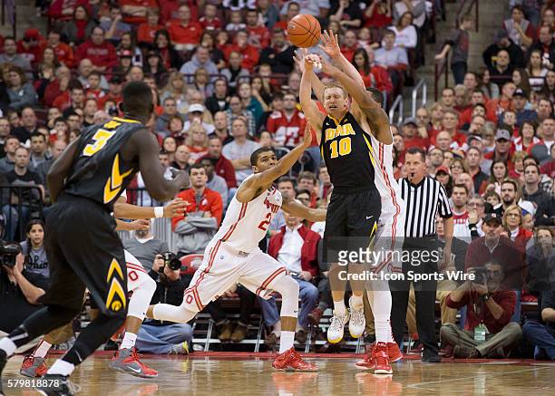 Mike Gesell of the Iowa Hawkeyes passes the ball being guarded by Marc Loving of the Ohio State Buckeyes and Amir Williams of the Ohio State Buckeyes...