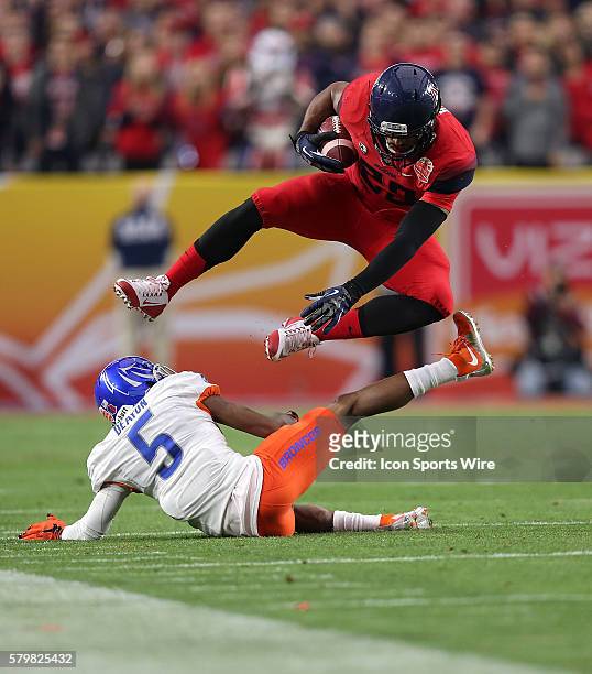 Arizona Wildcats wide receiver Austin Hill hurdles over Boise State Broncos cornerback Donte Deayon during the first quarter of the Vizio Fiesta Bowl...