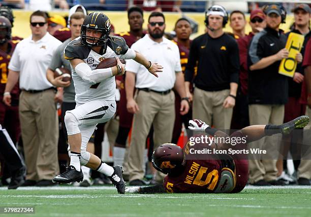 Missouri Tigers quarterback Maty Mauk slips thru the hands of Minnesota Golden Gophers linebacker Damien Wilson in the first half of play at the...