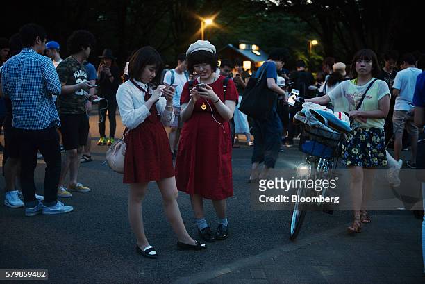 People play Nintendo Co.'s Pokemon Go augmented-reality game, developed by Niantic Inc., on their smartphones at Yoyogi Park in Tokyo, Japan, on...