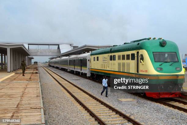 Man walks past a train of the newly completed Abuja-Kaduna night railway line in Abuja, on July 21, 2016. - Nigerias first high speed rails system...