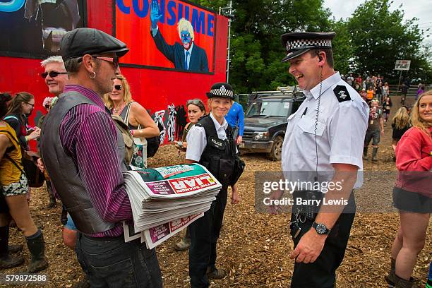 Selling the Shangri Liar, an ironic tabloit style newspaper raising money for the refugee kitchens in Calais and Dunkirk, to a policeman patrolling...