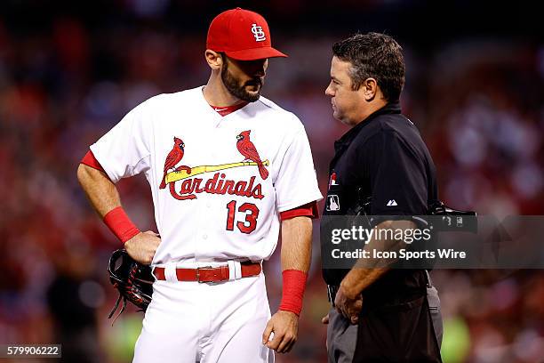 St. Louis Cardinals third baseman Matt Carpenter talks with umpire Rob Drake during a baseball game against the Milwaukee Brewers at Busch Stadium in...