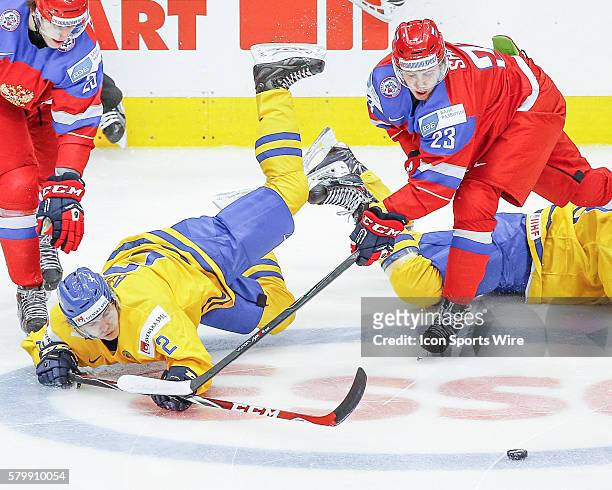 Alexander Sharov and Alexander Dergachyov of Russia scramble for puck against Sebastian Aho of Sweden during Russia's 4-1 victory over Sweden at the...