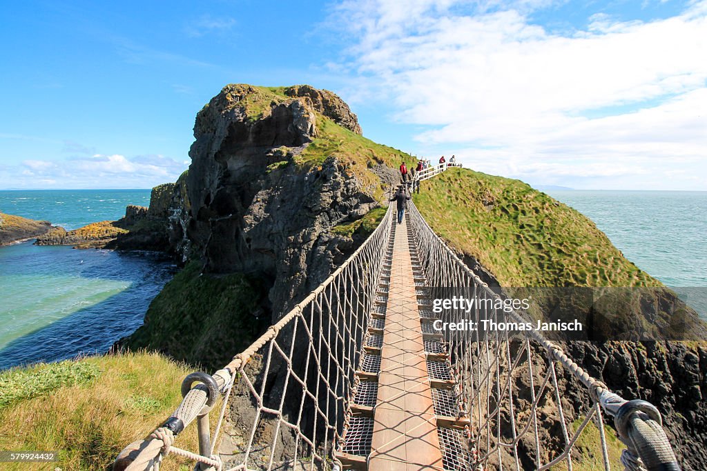 Standing on Carrick-a-Rede Rope Bridge, a famous rope bridge near Ballintoy in County Antrim, Northern Ireland, UK