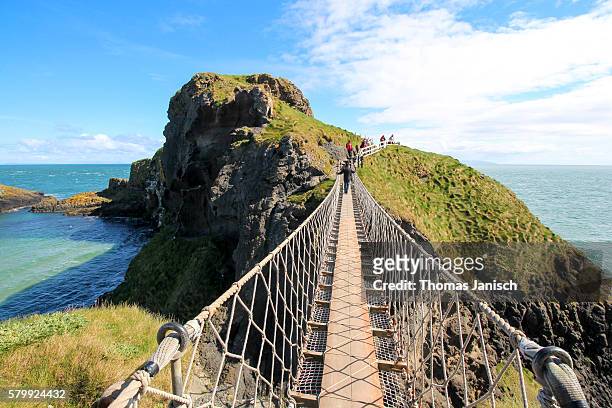 standing on carrick-a-rede rope bridge, a famous rope bridge near ballintoy in county antrim, northern ireland, uk - county antrim 個照片及圖片檔