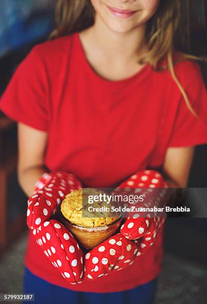 girl holding a cupcake in her hands with oven mitt - gant de cuisine photos et images de collection