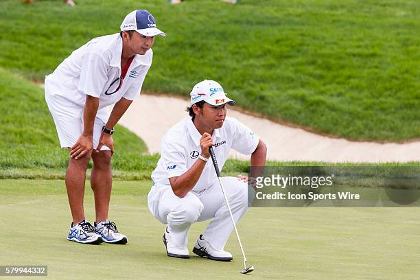 Hideki Matsuyama with the help of his caddy lines up his put on the 18th green during the final round of the Memorial Tournament presented by...