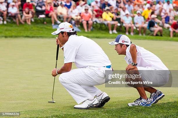 Hideki Matsuyama with the help of his caddy lines up his put on the 18th green during the final round of the Memorial Tournament presented by...