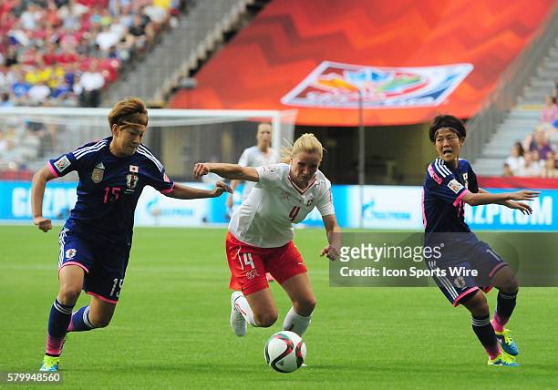 Switzerland's Rachel Rinast tries to take away with the ball between Japan's Yuika Sugasawa and Saori Ariyoshi at BC Place in Vancouver, British...