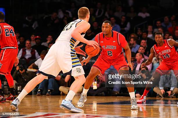 St. John's Red Storm forward Christian Jones defends Marquette Golden Eagles forward Henry Ellenson during the first half of the Big East Tournament...