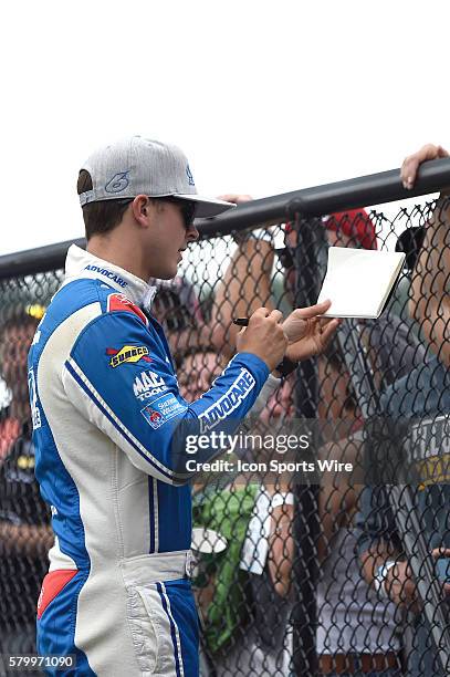 Trevor Bayne signs autographs on his way to driver introductions for the Quicken Loans 400 NASCAR Sprint Cup Series race at Michigan International...