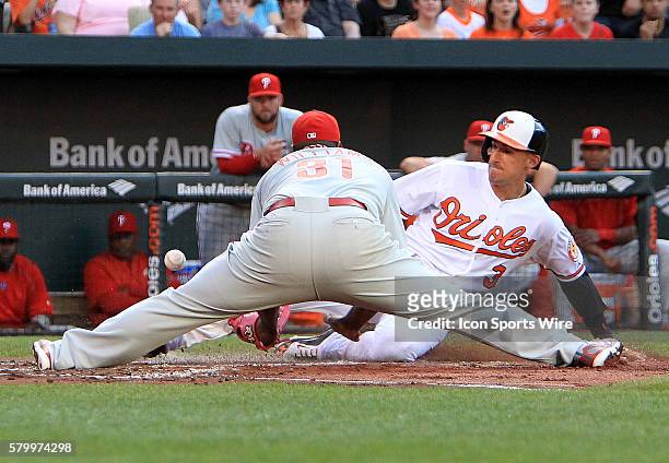 Baltimore Orioles second baseman Ryan Flaherty slides into home despite the efforts of Philadelphia Phillies starting pitcher Jerome Williams during...