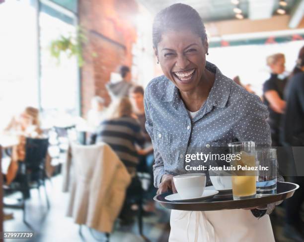 mixed race waitress serving coffee and lemonade in cafe - women serving coffee stock-fotos und bilder