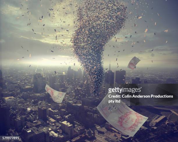 tornado of money over cityscape - british currency stockfoto's en -beelden