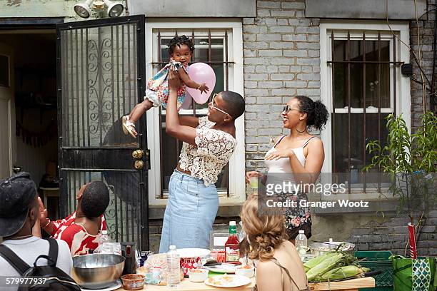 family enjoying backyard barbecue - barbecue social gathering stock pictures, royalty-free photos & images