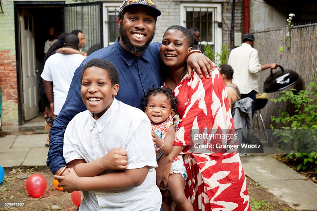 Family hugging at backyard barbecue