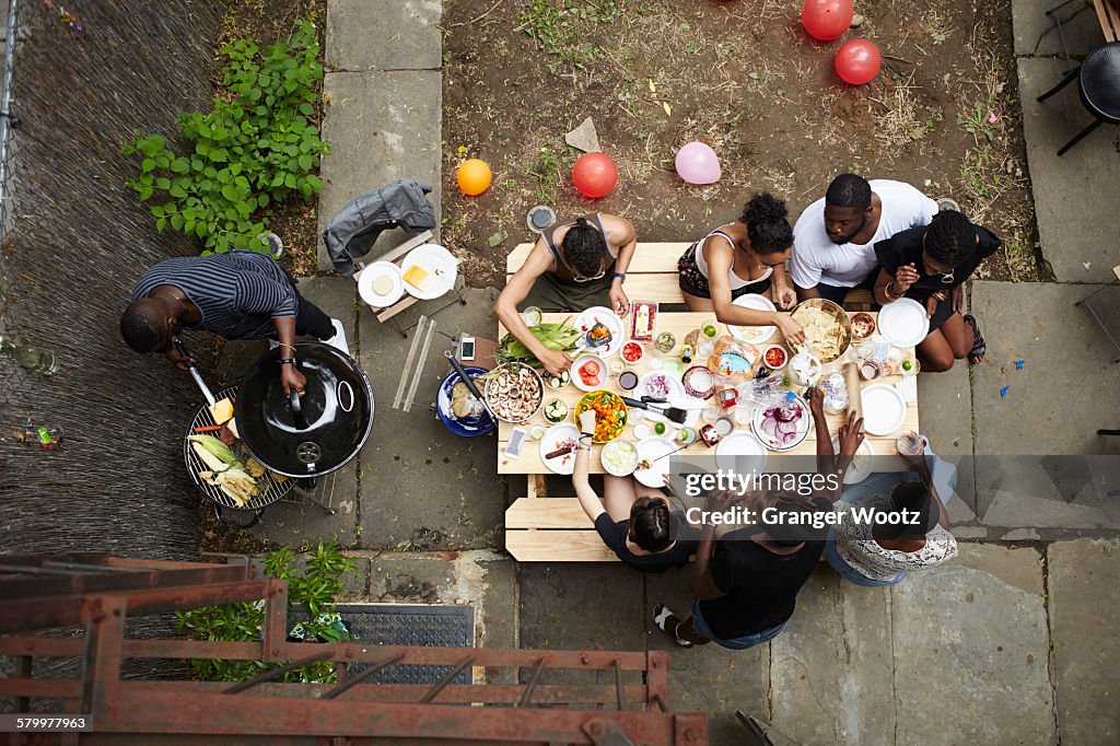 High Angle View Of Friends Enjoying Backyard Barbecue High-Res