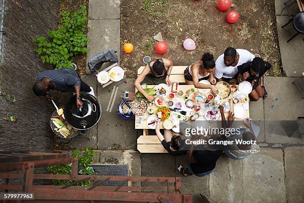 high angle view of friends enjoying backyard barbecue - overhead view stock pictures, royalty-free photos & images