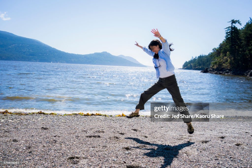 Japanese woman doing cartwheel on beach