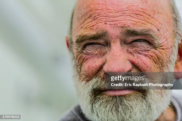 close up of wrinkled face of caucasian man - entrecerrar los ojos fotografías e imágenes de stock