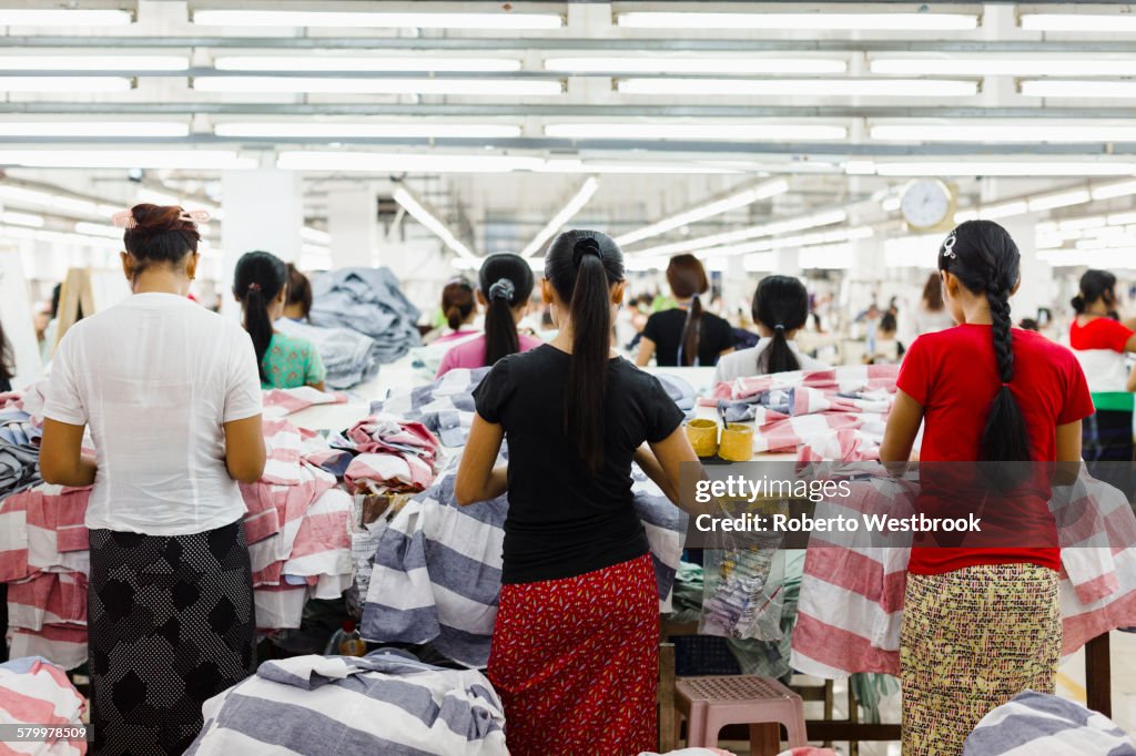Asian workers sewing clothing in garment factory