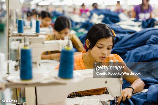 asian worker sewing clothing in garment factory - woman sewing bildbanksfoton och bilder