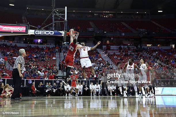 Rebels forward Stephen Zimmerman Jr. #33 dunks over Fresno State Bulldogs guard Julien Lewis during the first half of the Mountain West tournament...