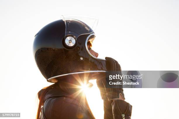 caucasian woman wearing motorcycle helmet - crash helmet stock-fotos und bilder