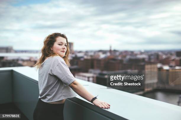 caucasian woman on urban rooftop admiring cityscape - boston women ストックフォトと画像