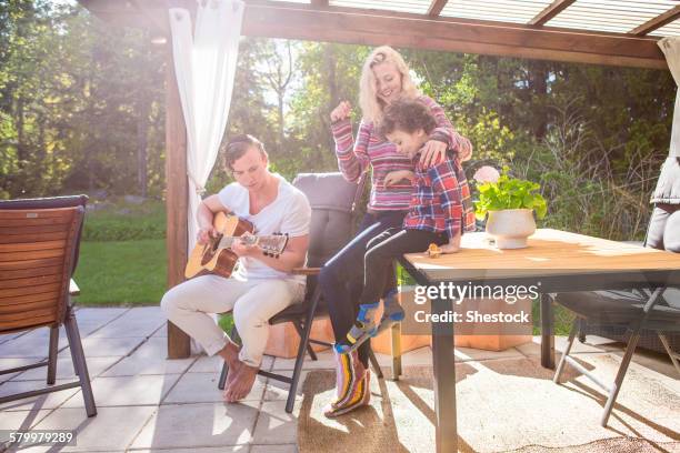 family relaxing on backyard patio - cenador fotografías e imágenes de stock