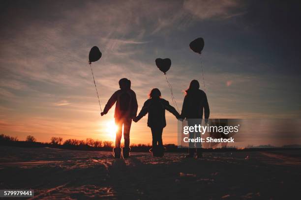 caucasian girls walking with balloons at sunset - día de san valentín festivo fotografías e imágenes de stock
