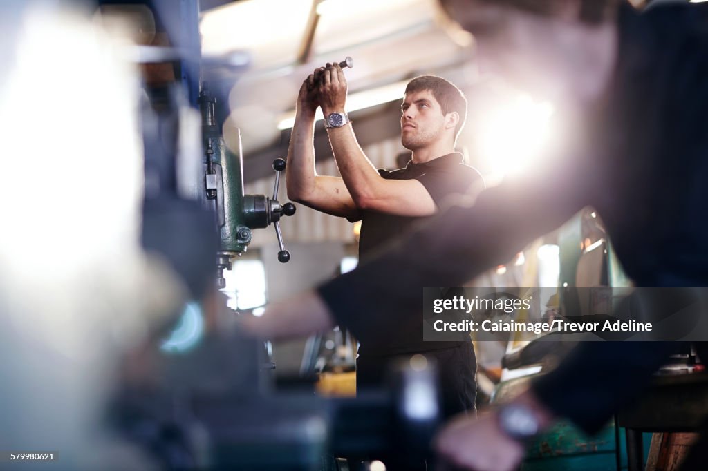 Mechaniker prüft Teil in Autowerkstatt