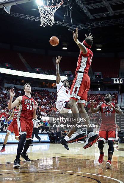 Fresno State Bulldogs guard Julien Lewis shoots between UNLV Rebels forward Stephen Zimmerman Jr. #33 and guard Patrick McCaw during the second half...