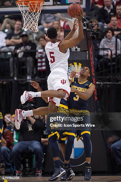 Indiana Hoosiers forward Troy Williams jumps over Michigan Wolverines forward Kameron Chatman for a score during the men's Big Ten Tournament...