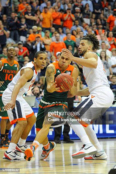 Miami Hurricanes guard Angel Rodriguez drives against Virginia Cavaliers guard Malcolm Brogdon and guard London Perrantes in the semifinal of the ACC...