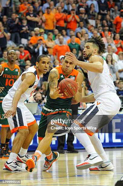 Miami Hurricanes guard Angel Rodriguez drives against Virginia Cavaliers guard Malcolm Brogdon and guard London Perrantes in the semifinal of the ACC...