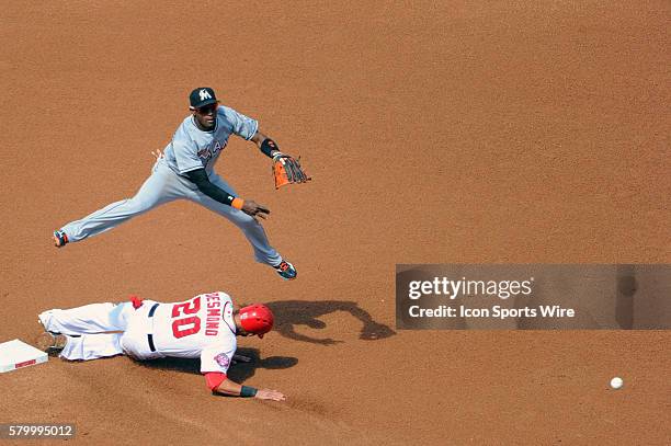 Miami Marlins shortstop Adeiny Hechavarria completes a double play against Washington Nationals shortstop Ian Desmond at Nationals Park in...