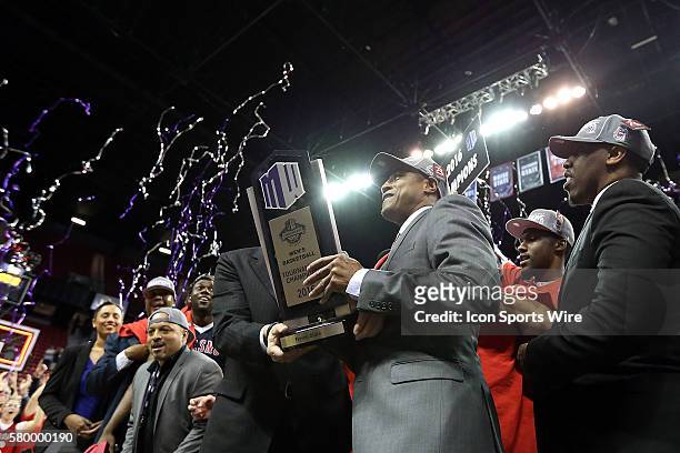 Fresno State Bulldogs head coach Rodney Terry celebrates with the Mountain West College Basketball conference tournament championship trophy after...