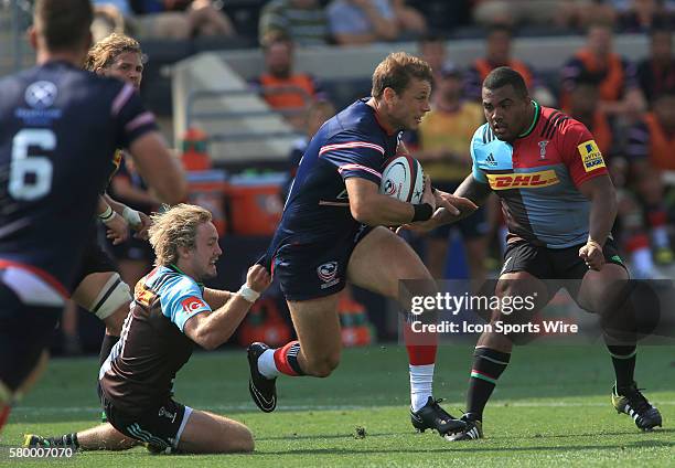 Blaine Scully of the USA Eagles is pulled down by Charlie Walker of Harlequins during an international rugby friendly match at PPL Park, in Chester,...