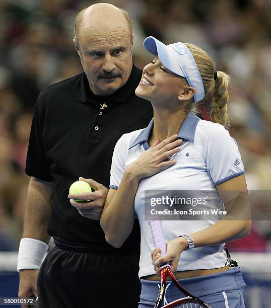 Teamates Dr. Phil McGraw and Anna Kournikova talk with each other during the Serving for Tsunami Relief tennis match at Toyota Center in Houston,...