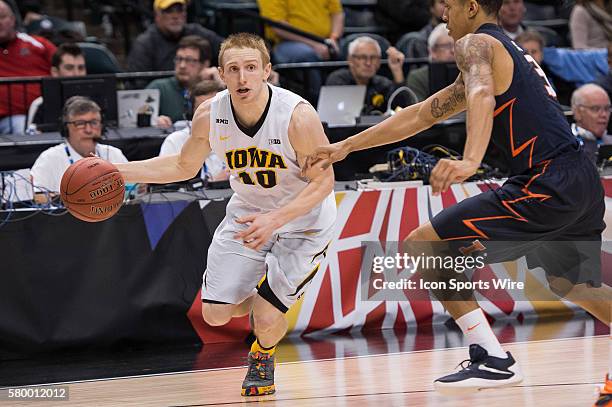 Iowa Hawkeyes guard Mike Gesell drives by Illinois Fighting Illini guard Khalid Lewis during the men's Big Ten Tournament basketball game between the...