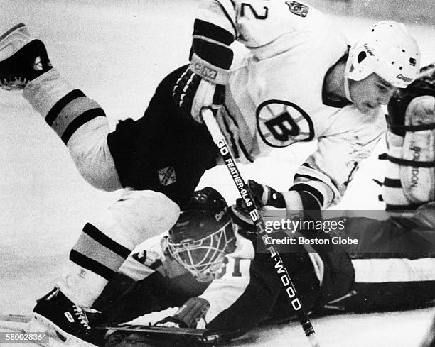 Boston Bruins player Randy Burridge, top, jumps over Toronto Maple Leafs goaltender Ken Wregget, bottom, in the first period of a game at the Boston...