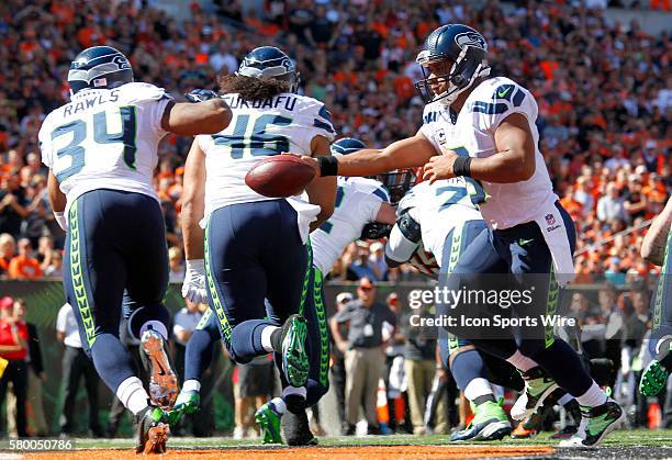 Seattle Seahawks quarterback Russell Wilson hands off football to Thomas Rawls under pressure from Cincinnati Bengals at Paul Brown Stadium in...