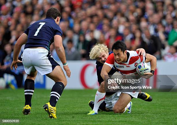 Japan's Kenki Fukuoka is tackled by Scotland's Richie Gray during the 2015 Rugby World cup match-up between Japan and Scotland being held at...