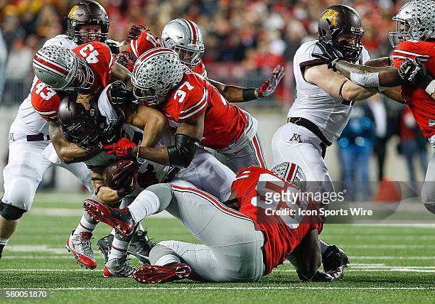 Minnesota Golden Gophers running back James Johannesson is tackled by Ohio State Buckeyes linebacker Darron Lee and Ohio State Buckeyes linebacker...