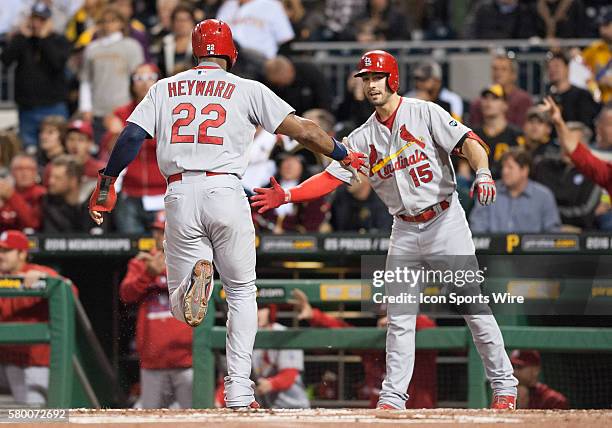 St. Louis Cardinals right fielder Jason Heyward is greeted by left fielder Randal Grichuk after scoring on an RBI double by first baseman Matt Adams...